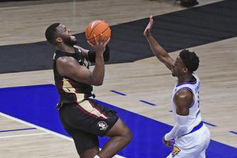 Florida State forward Raquan Gray, left, goes in for a shot over Pittsburgh guard Xavier Johnson during the first half on Saturday in Pittsburgh. (FRED VUICH/Associated Press)