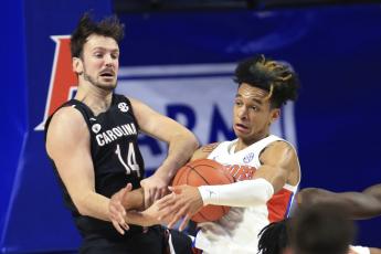 Florida guard Tre Mann, right, and South Carolina forward Nathan Nelson (14) struggle for a rebound on Feb. 3 in Gainesville. (MATT STAMEY/Associated Press)