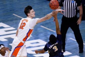 Florida forward Colin Castleton (12) blocks a shot by Oral Roberts guard Max Abmas (3) during the second round of the NCAA Tournament at Indiana Farmers Coliseum on March 21 in Indianapolis. (AJ MAST/Associated Press)