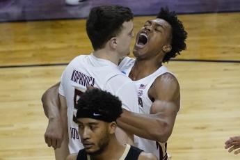 Florida State center Balsa Koprivica (5) gets a hug from teammate Scottie Barnes, right, after a dunk against Colorado in the second round of the NCAA Tournament at Farmers Coliseum on Monday in Indianapolis. (CHARLES REX ARBOGAST/Associated Press)