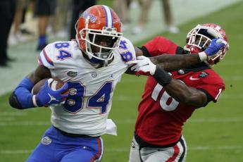 Florida tight end Kyle Pitts (84) tires to get past Georgia defensive back Lewis Cine (16) after a reception on Nov. 7, 2020, in Jacksonville. (AP PFILE PHOTO)