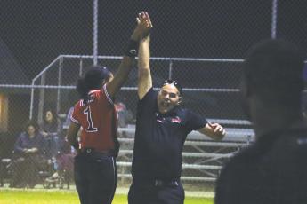 Fort White shortstop Ciara Byrd high fives assistant coach Chad Padgett after bringing in the winning runs against Madison County on Monday night. (MORGAN MCMULLEN/Lake City Reporter)