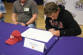 Columbia runner Cole Chancey signs his letter of intent to attend Flagler College on Wednesday. (JORDAN KROEGER/Lake City Reporter)