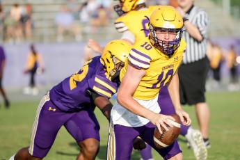 Columbia quarterback Kade Jackson scrambles away from pressure during last Friday’s Purple & Gold game. (BRENT KUYKENDALL/Lake City Reporter)
