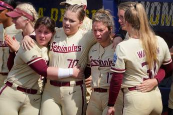 Florida State players Kaia LoPreste (from left), Cassidy Davis, Anna Shelnutt, Emma Wilson and Danielle Watson watch as Oklahoma players accept awards after they defeated Florida State in the final game of the Women's College World Series championship series Thursday in Oklahoma City. (SUE OGROCKI/Associated Press)