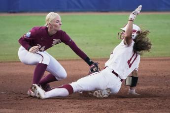 Florida State third baseman Sydney Sherrill tags out Oklahoma's Nicole Mendes (11) during the second inning in Game 1 of the Women's College World Series championship series on Tuesday in Oklahoma City. (SUE OGROCKI/Associated Press)