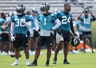 Jacksonville Jaguars running backs James Robinson (30), Travis Etienne (1) and Carlos Hyde (24) on the field during drills at an OTA session on May 27. (BOB SELF/Florida Times-Union/TNS)
