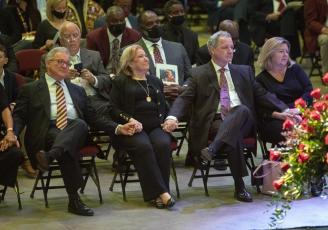 Sons Terry Bowden, left, and Tommy Bowden hold hands with their mother, Ann, second from left, during a celebration of life ceremony for their father and her husband, longtime Florida State football coach Bobby Bowden, as he lies in repose at the Tucker Civic Center on Saturday in Tallahassee. (MARK WALLHEISER/Associated Press)