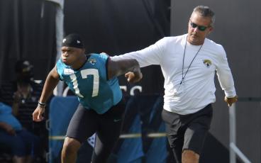 Jacksonville Jaguars head coach Urban Meyer holds wide receiver DJ Chark Jr. by the jersey as he works with him at the start of practice in July 30 in Jacksonville. (BOB SELF/The Florida Times-Union/TNS)
