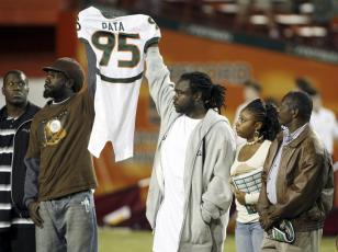 Bryan Pata's family hold up his jersey at the beginning of a game between Miami and Boston College at the Orange Bowl on Nov. 23, 2006, in Miami. Rashaun Jones, 35, of Lake City, a former University of Miami football player was arrested Thursday in connection with the 2006 fatal shooting of his teammate Bryan Pata. Pata, a 22-year-old, 6-foot-4, 280-pound defensive lineman, was shot several times outside of his Kendall apartment the night of Nov. 7, 2006. (AP FILE PHOTO)