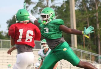 Suwannee defensive lineman Austin Smith tries to swat a pass from quarterback Bronsen Tillotson during a team scrimmage on Saturday. (JAMIE WACHTER/Lake City Reporter)