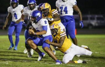 Columbia defensive end Adeon Farmer (7) attempts to tackle Trinity Christian quarterback Colin Hurley as defensive tackle Garris Reed (58) gives chase last Friday. (BRENT KUYKENDALL/Lake City Reporter)