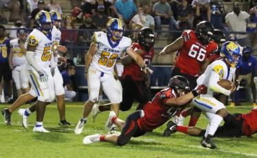 Fort White linebacker Coby Lee dives to tackle Newberry quarterback Trae Butler on Friday night. (MORGAN MCMULLEN/Lake City Reporter)