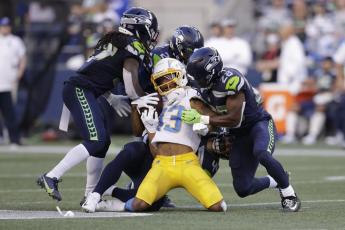 Los Angeles Chargers wide receiver Tyron Johnson, center, is brought down by Seattle Seahawks' Marquise Blair, Damarious Randall and Ugo Amadi, from left, during a preseason game on Aug. 28 in Seattle. (JOHN FROSCHAUER/Associated Press)