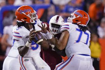 Florida quarterback Emory Jones, left, throws a pass as he get a block from offensive lineman Ethan White (77) against Florida Atlantic on Saturday in Gainesville. (JOHN RAOUX/Associated Press)