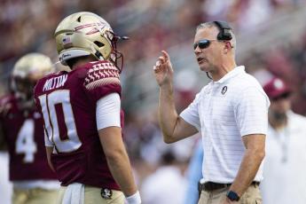 Florida State head coach Mike Norvell talks with quarterback McKenzie Milton during a game against Louisville on Sept. 25 in Tallahassee. (MARK WALLHEISER/Associated Press)