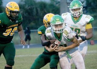 Suwannee quarterback Kodi Lang gets tackled by Ed White on Friday night. (JAMIE WACHTER/Lake City Reporter)