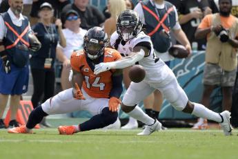 Denver Broncos wide receiver Courtland Sutton (14) catches a pass despite defensive effort by Jacksonville Jaguars cornerback Chris Claybrooks, right, on Sept. 19 in Jacksonville. (PHELAN M. EBENHACK)