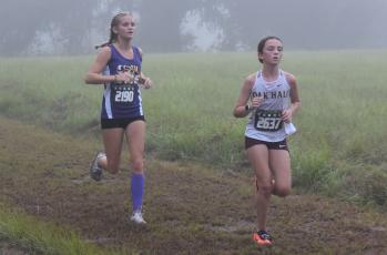 Columbia runner Abigail Candler (left) runs at the Alligator Lake XC Invite on Saturday. (COURTESY)