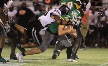 Suwannee quarterback Kodi Lang is tackled by a Hawthorne defender on Friday night. (PAUL BUCHANAN/Special to the Reporter)