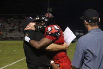 Fort White fullback Kamarion Griffin hugs a coach Friday night after an 85-yard touchdown run. (MORGAM MCMULLEN/Lake City Reporter)