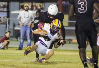 Columbia quarterback Evan Umstead is sacked by Madison County on Friday. (BRENT KUYKENDALL/Lake City Reporter)