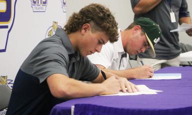 Columbia baseball players Truitt Todd (left) and Brent Howard (right) sign their letters of intent on Wednesday. Todd signed with Florida State College at Jacksonville and Howard signed with Jacksonville. (JORDAN KROEGER/Lake City Reporter)
