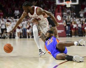 Florida guard Brandon McKissic slips as he tries to steal the ball away from Oklahoma guard Elijah Harkless during Wednesday’s game in Norman, Okla. (KYLE PHILLIPS/Associated Press)