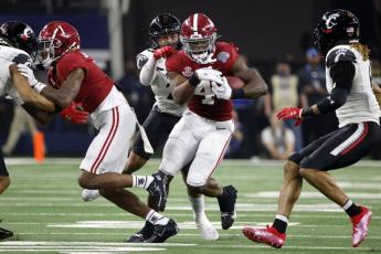 Alabama running back Brian Robinson Jr. runs for a first down as Cincinnati linebacker Deshawn Pace reaches from behind to tackle him during the Cotton Bowl College Football Playoff semifinal game on Friday in Arlington, Texas. Alabama won 27-6. (MICHAEL AINSWORTH/Associated Press)