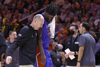 Florida center Jason Jitoboh is led off the court after being injured on a play against Tennessee on Wednesday in Knoxville, Tenn. (WADE PAYNE/Associated Press)