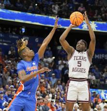 Texas A&M guard Hassan Diarra makes the game-winning shot over Florida guard Kowacie Reeves during overtime of Thursday's game at the Southeastern Conference tournament in Tampa. (CHRIS O'MEARA/Associated Press)