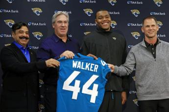 Jacksonville Jaguars owner Shad Khan (from left) head coach Doug Pederson, first-round draft pick Travon Walker, and general manager Trent Baalke hold up Walker’s jersey during a press conference Friday at TIAA Bank Field in Jacksonville. (COREY PERRINE/The Florida Times-Union via AP)