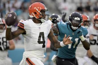 Cleveland Browns quarterback Deshaun Watson looks for a receiver as he is pressured by Jacksonville Jaguars linebacker Josh Allen during Friday’s preseason game in Jacksonville. (PHELAN M. EBENHACK/Associated Press)
