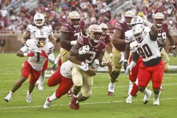 Florida State running back Trey Benson (3) fights for extra yardage as Duquesne defenders pursue in the Seminoles' Week 1 game in Tallahassee. (PHIL SEARS/Associated Press)