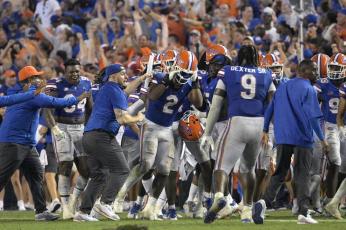 Florida linebacker Amari Burney (2) is swarmed by teammates on the sideline after making a game-saving interception in the end zone near the end of Saturday's game against Utah in Gainesville. (PHELAN M. EBENHACK/Associated Press)