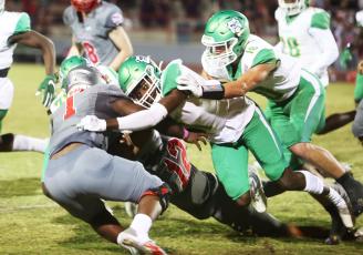 Santa Fe running back Javarous Evans is wrapped up by a slew of Suwannee defenders including DJ Coleman (1) and Kodi Lang (10). (PAUL BUCHANAN/Special to the Reporter)