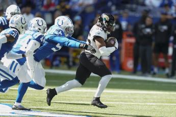 Jacksonville Jaguars running back James Robinson runs past Indianapolis Colts defensive end Dayo Odeyingbo on Oct. 16 in Indianapolis. (MICHAEL CONROY/Associated Press)