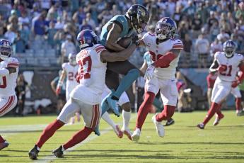 Jacksonville Jaguars wide receiver Christian Kirk (13) is stopped by New York Giants cornerback Fabian Moreau (37) and safety Julian Love (20) during Sunday's game in Jacksonville. (PHELAN M. EBENHACK/Associated Press)