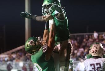 Suwannee receiver Kodi Lang (left) raises up running back Marquavious Owens as the two celebrate following Owens’ touchdown against Madison County on Oct. 14. (PAUL BUCHANAN/Special to the Reporter)