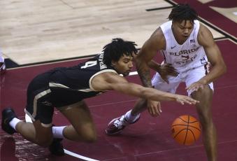 Purdue forward Trey Kaufman-Renn (4) and Florida State forward Cameron Corhen reach for the ball during Wednesday's game in Tallahassee. (PHIL SEARS/Associated Press)