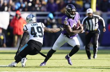 Baltimore Ravens quarterback Lamar Jackson gets by Carolina Panthers linebacker Frankie Luvu on Nov. 20 in Baltimore. (PATRICK SEMANSKY/Associated Press)