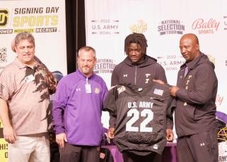 Columbia linebacker Jaden Robinson (center right) was presented with a U.S. Army All-American by U.S. Army Bowl Director Marc Boldurian (left) during a ceremony at Columbia High School on Thursday. The two are pictured with principal Trey Hosford (center left) and head coach Demetric Jackson (right). (JAMIE WACHTER/Lake City Reporter)