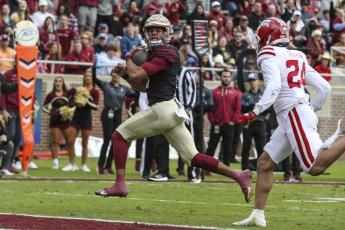 Florida State quarterback Jordan Travis runs for a touchdown against Louisiana on Nov. 19 in Tallahassee. (GARY MCCULLOUGH/Associated Press)