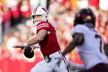Wisconsin quarterback Graham Mertz throws a pass as Minnesota defensive back Beanie Bishop pressures on Nov. 26 in Madison, Wis. (ANDY MANIS/Associated Press)