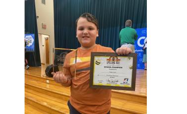 Fort White Elementary School’s Tucker Ayers shows off his awards for winning the Columbia County Spelling Bee on Friday. (COURTESY)