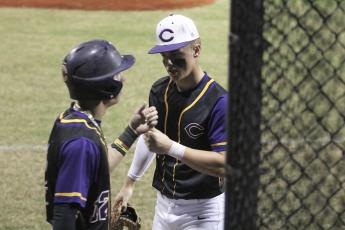Columbia’s Hayden Gustavson (right) fist bumps Camdon Frier after Frier scored a run against Gainesville on Friday night. (JORDAN KROEGER/Lake City Reporter)