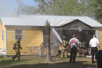 Firefighters from Columbia County Fire Rescue and the Lake City Fire Department extinguish a fire in a house on NE James Avenue late Wednesday morning. (JAMIE WACHTER/Lake City Reporter)
