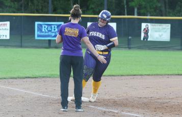 Columbia third baseman Alexis Blair high fives assistant coach Hayes Fulford as she rounds third base after one of her two home runs against Baker County on Monday night. (MORGAN MCMULLEN/Lake City Reporter)