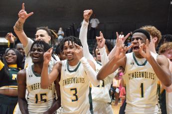 FGC players Maurice Campbell (15), Jeremy Young (3) and Jeremiah Barze (1) celebrate after defeating Palm Beach State to win the Region 8 title on Saturday. (COURTESY OF FGC)