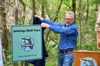 Harley Means, the state geologist and director of the Florida Geological Survey, unveils a new marker certifying the Jennings Bluff Tract as a State Geological Site on Friday. (COURTESY SRWMD)